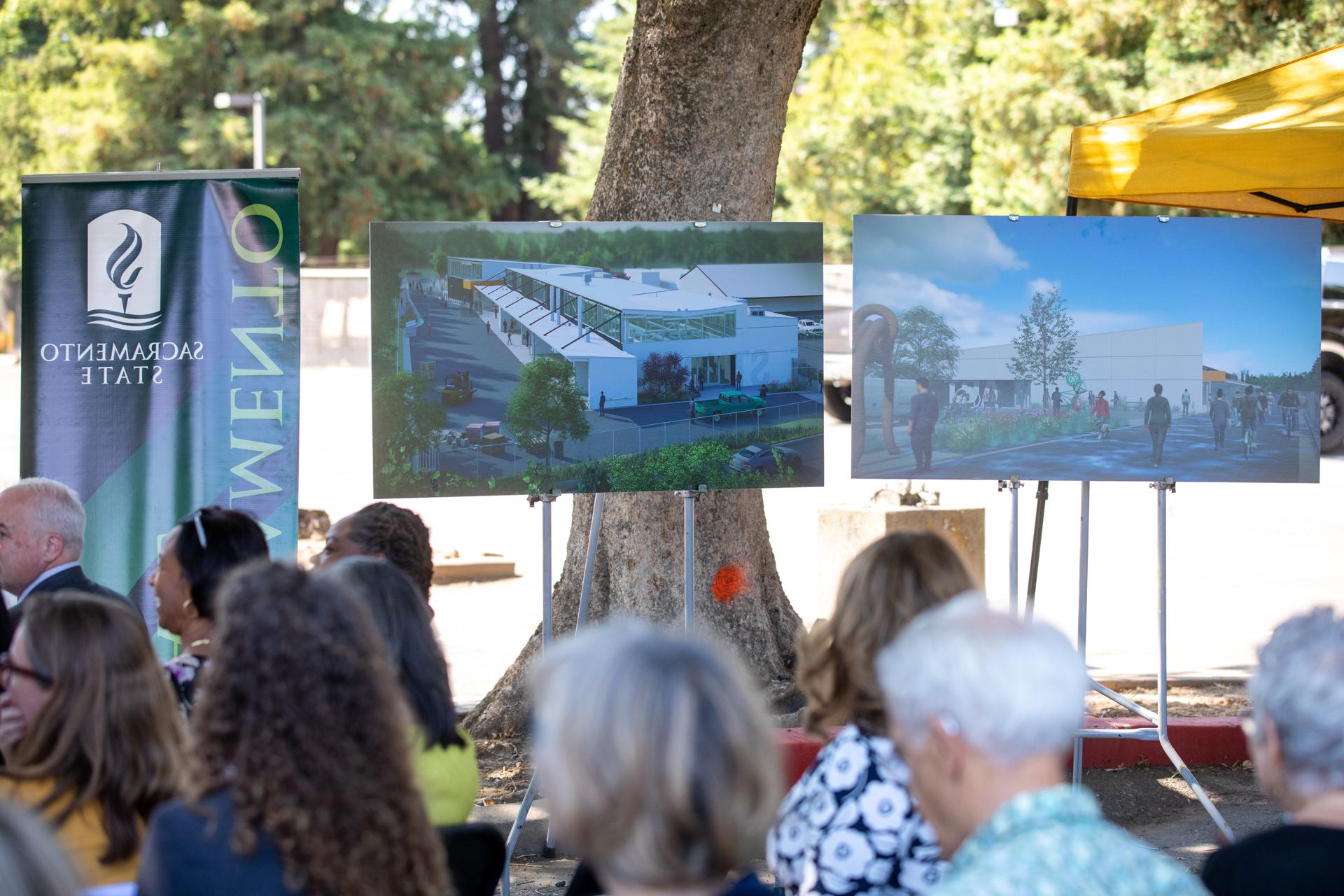Attendees at the groundbreaking with renderings of the new building